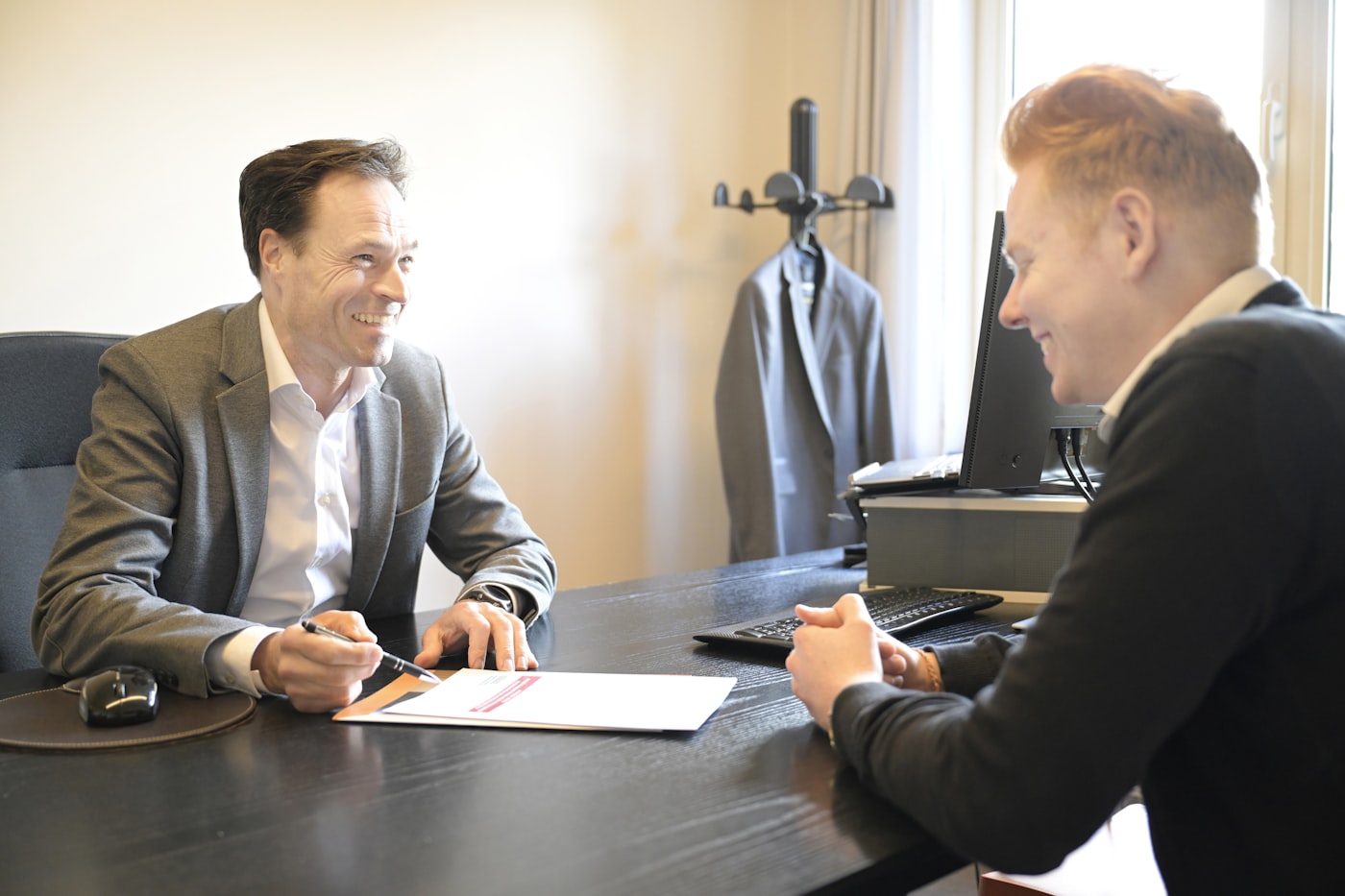 Two people reviewing documents together, smiling