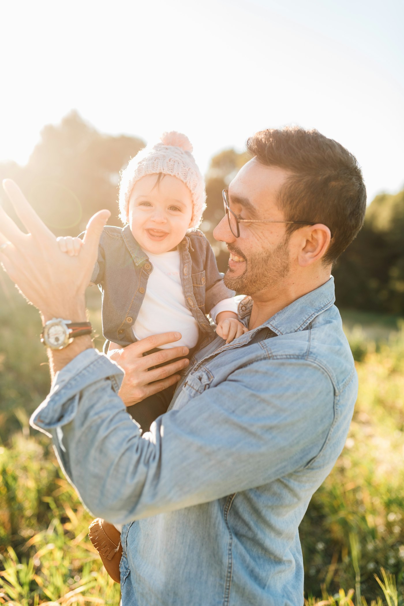 Father laughing with his baby daughter outdoors